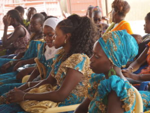 Senegalilaisia naisia istumassa koulun päättäjäisjuhlassa.