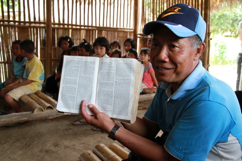 Evankelista Yothin Yodkeeree esittelee lisunkielistä Raamattua. Thaimaan luterilainen kirkko kasvaa nopeimmin maaseudulla.
