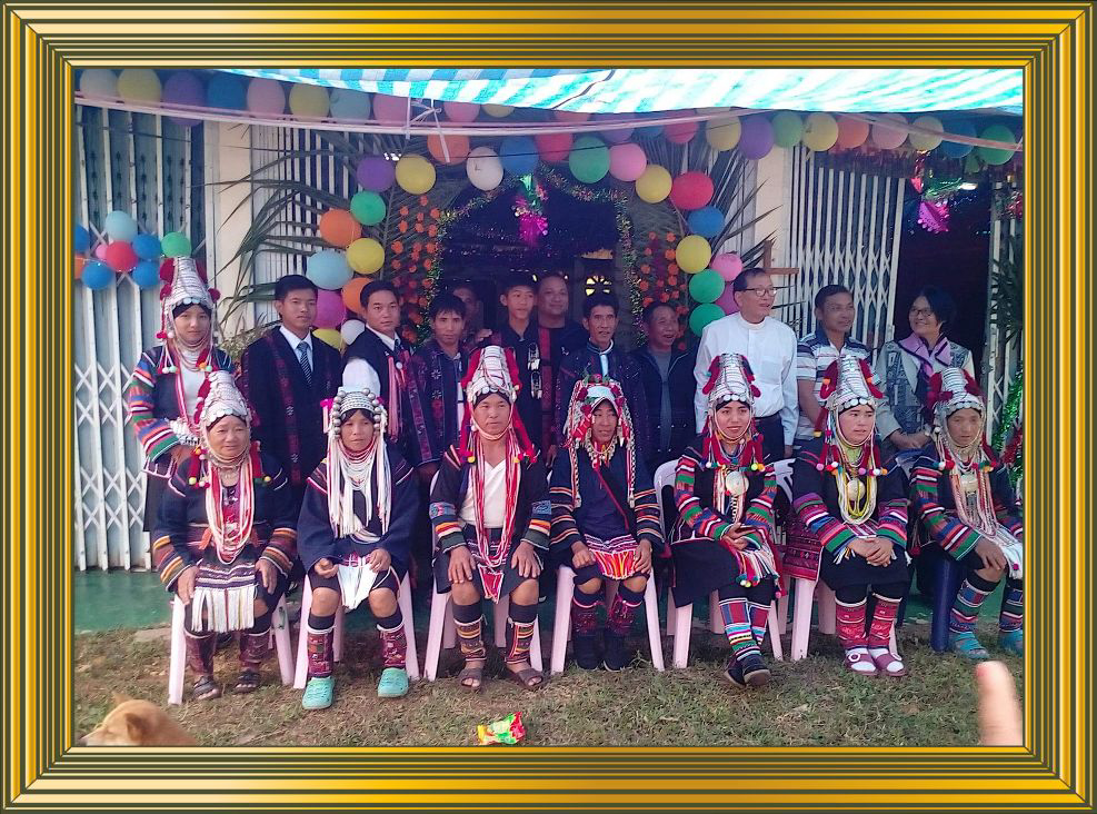 Ryhmäkuvassa parikymmentä värikkäisiin perinneasuihin pukeutuneita seurakuntalaisia.