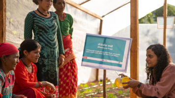 Sahas-järjestön työntekijä ja neljä nepalilaista kyläläistä ovat kasvihuoneen sisällä.