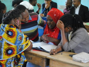 Tansanialaisia naisopettajia koulutuksessa pulpettien ääressä.