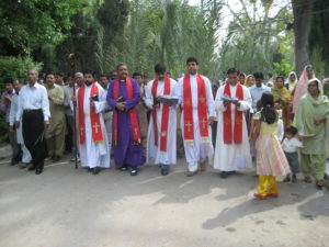 Joukko pakistanilaisia pappeja ja muuta kirkkoväkeä kulkueessa.