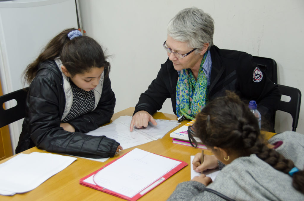 Vapaaehtoinen opettaja auttaa lapsia Ranskan Marhaban-keskuksessa.