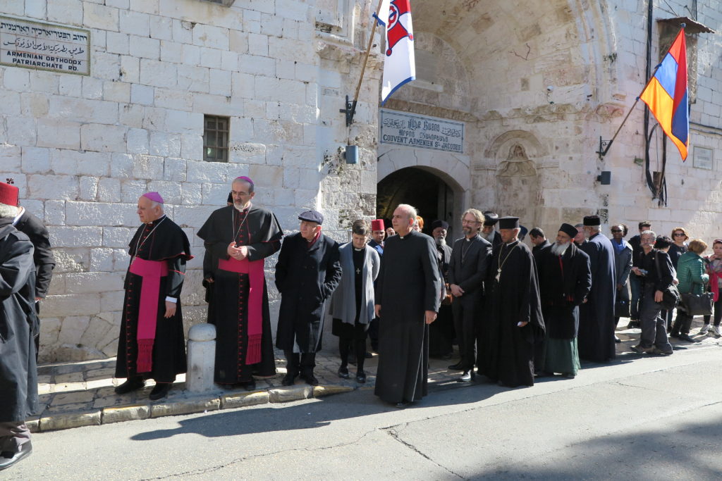 Joukko erilaisiin kristillisiin uskontokuntiin kuuluvia pappeja kirkon ulkopuolella Jerusalemissa.