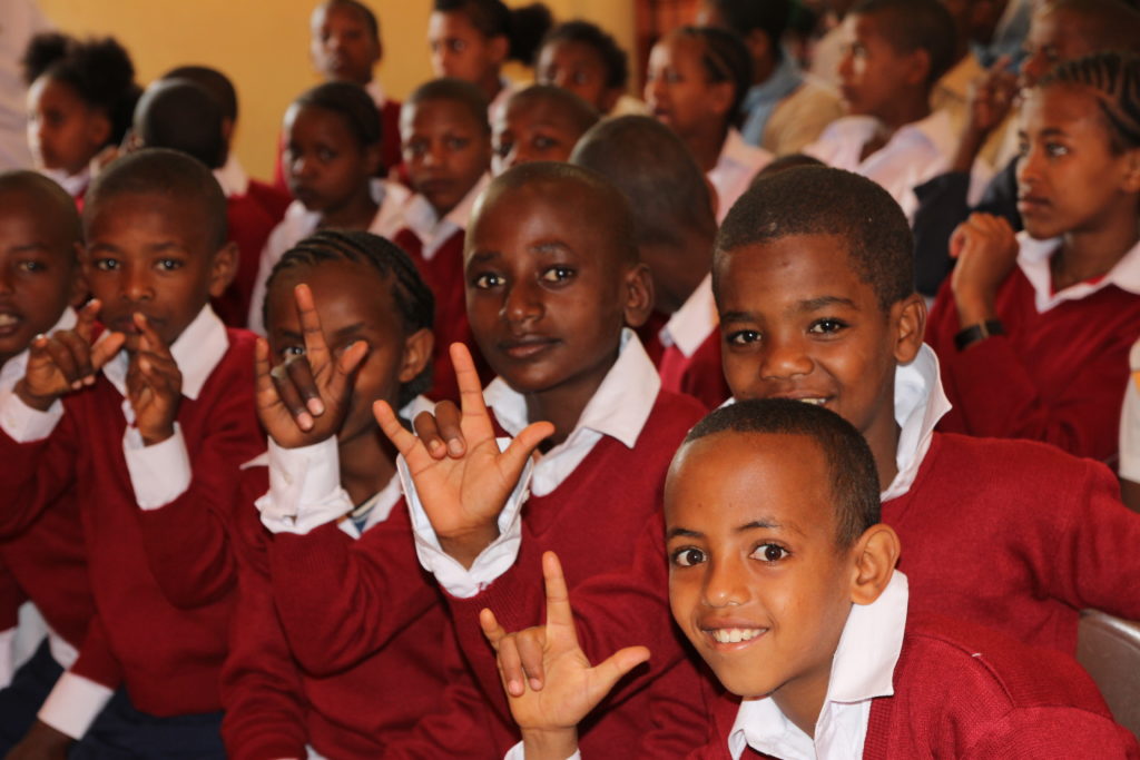 Etiopialaisia poikia punaisissa koulupuvuissa.