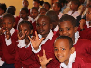 Etiopialaisia poikia punaisissa koulupuvuissa.