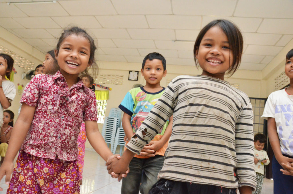 Iloisia kambodzhalaisia lapsia käsi kädessä.
