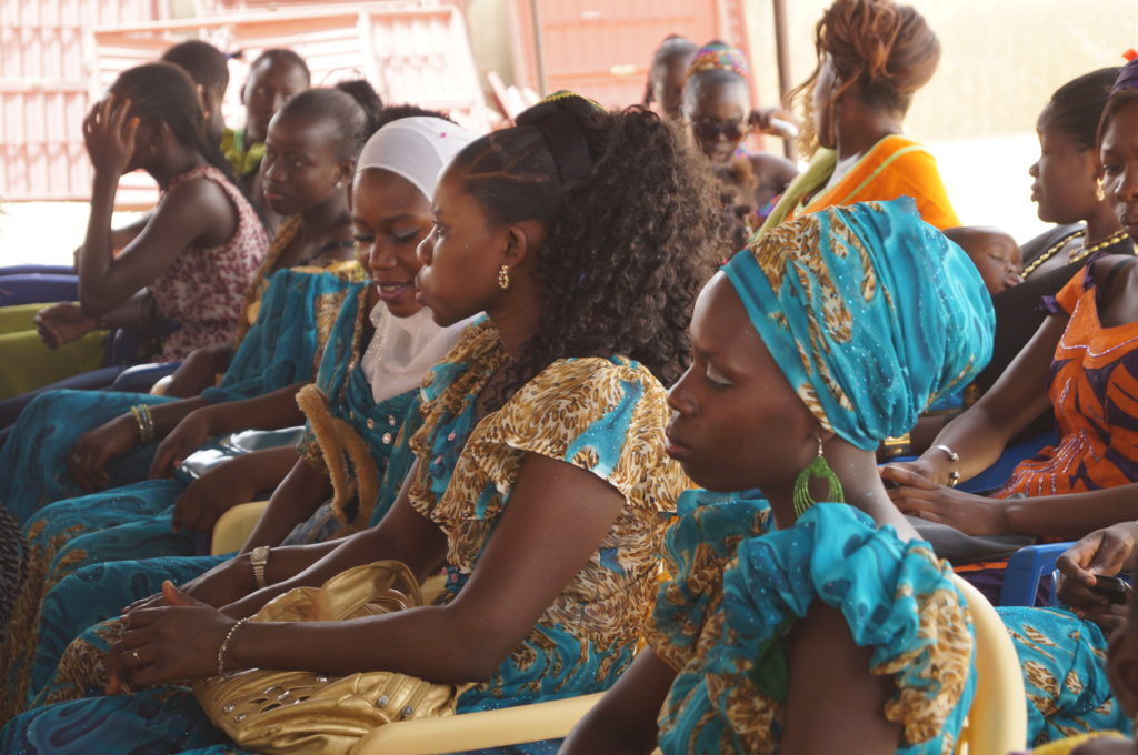 Senegalilaisia naisia istumassa koulun päättäjäisjuhlassa.