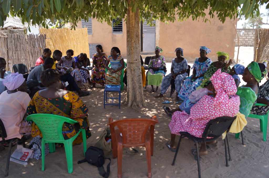 Senegalilaisia kokoontuneena keskustelupiiriin puun alle.