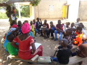 Senegalilaiset lapset istuvat ringissä seuraamassa pyhäkouluopetusta.