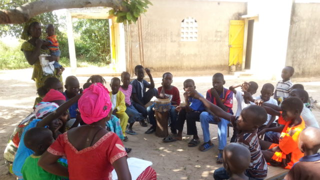 Senegalilaiset lapset istuvat ringissä seuraamassa pyhäkouluopetusta.