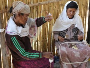 Kaksi iäkästä etiopialaista naista kehrää lankaa.