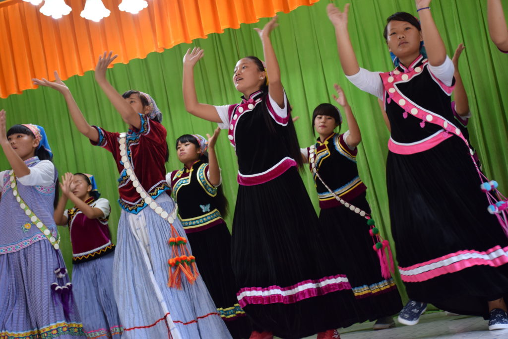Nuoret kiinalaiset naiset tanssivat kansanasuissa.