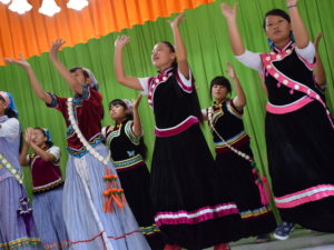 Nuoret kiinalaiset naiset tanssivat kansanasuissa.