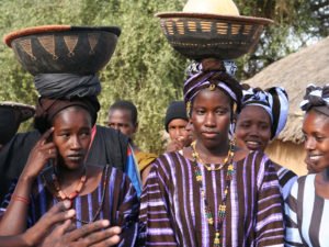 Mauritanialaisia naisia perinteisissä asuissa korit päidensä päällä.