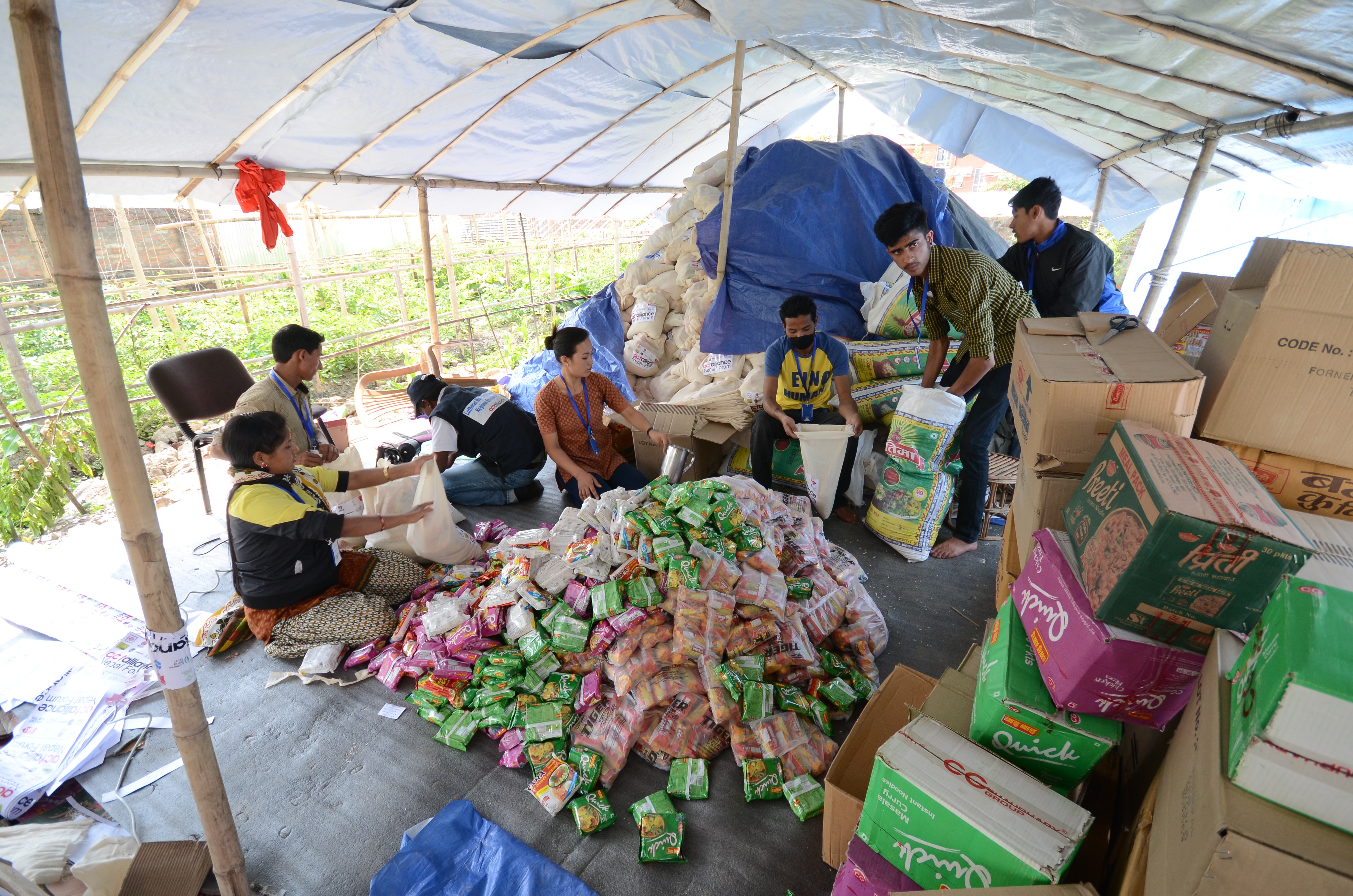 Kathmandussa satakunta paikallista vapaaehtoista auttaa Luterilaisen maailmanliiton omia työntekijöitä. He pakkaavat muun muassa avustuspakettiin tulevia ruokatarvikkeita. Kuva: Heikki Takko