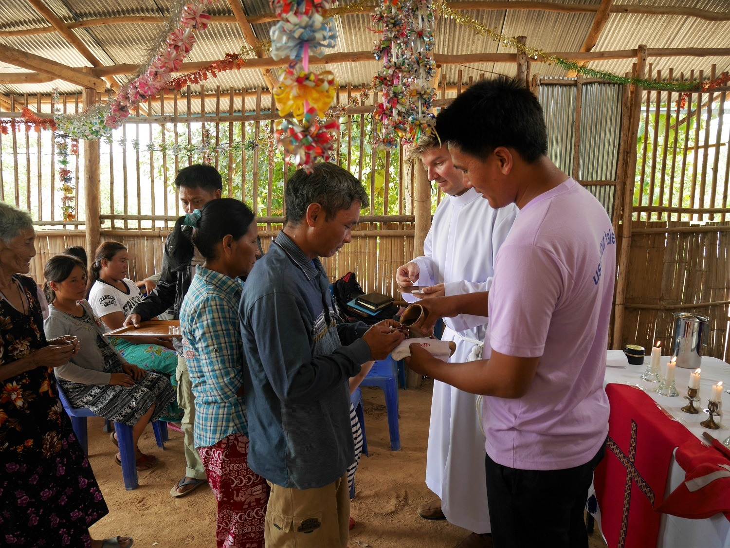 Evankelista Kanee ja Tomas Kolkka jakavat ehtoollista Saithoongin seurakunnan messussa. Saithoong on pieni maaseutuseurakunta lähellä Myanmarin rajaa. Seurakunnan jäsenet kuuluvat lahu-vähemmistökansaan. Kuva Riikka-Maria Kolkka