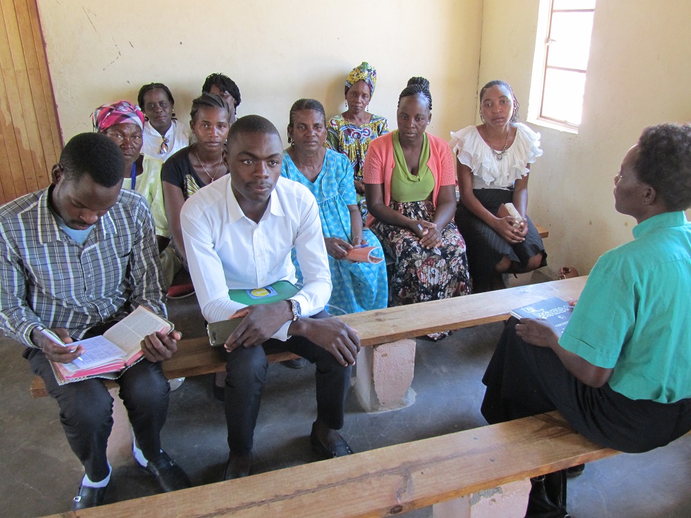 Maria Ndilishange keskustelee diakonia-avustajien kanssa.