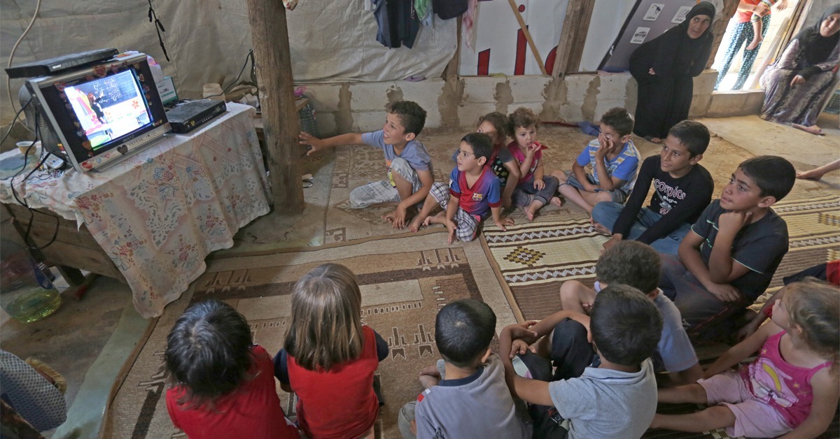 Lapset katsovat Minun kouluni -ohjelmaa pakolaisleirillä Libanonissa.