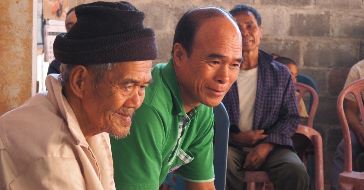 Herra Phet Jaiping odottamassa kastejuhlan alkamista yhdessä poikansa evankelista Manas Jaipingin kanssa.