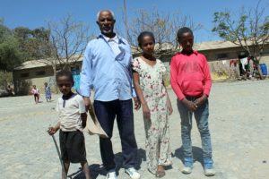 Amanuel Yemane pojanpoikansa, tyttärensä ja poikansa kanssa Hawultien koulussa Mekellessä.