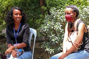 Teologian opiskelija Sena Feyissa ja Mihiret Gosaye istuvat puutarhatuoleilla ulkona.