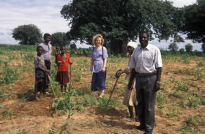 Pirre Saario angolalaisen perheen keskellä pellolla.