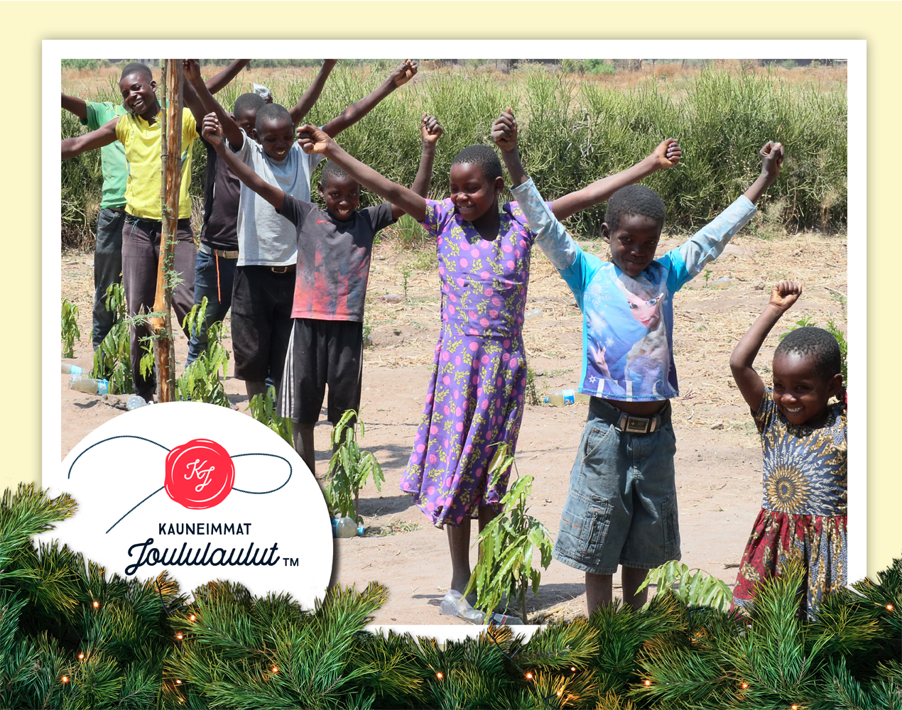 Tansanialaislapsia jonossa nimikkopuuntaimiensa vieressä kädet ylhäällä voitonmerkkinä.
