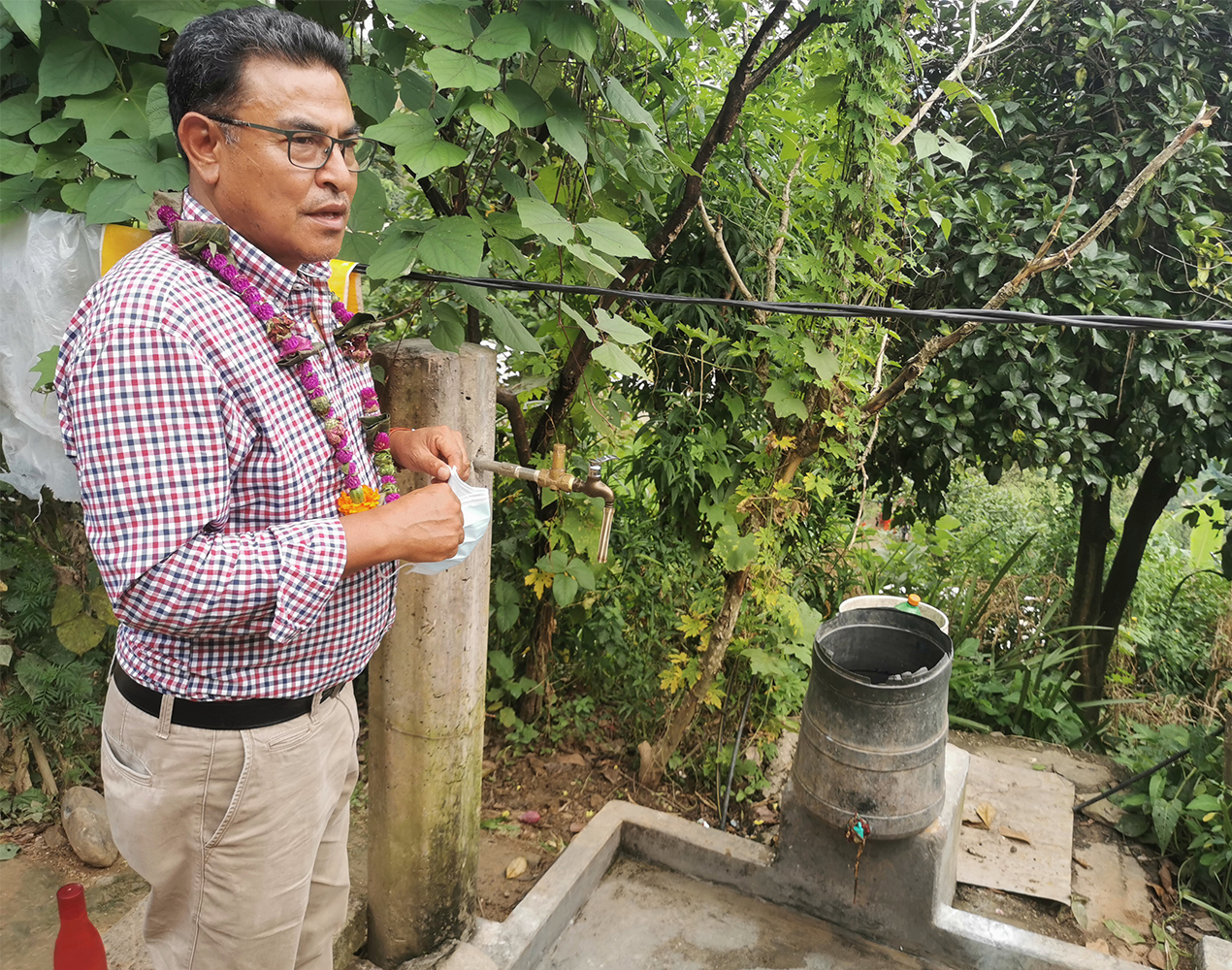 Surendra Shrestha seisoo vesihanan vieressä.
