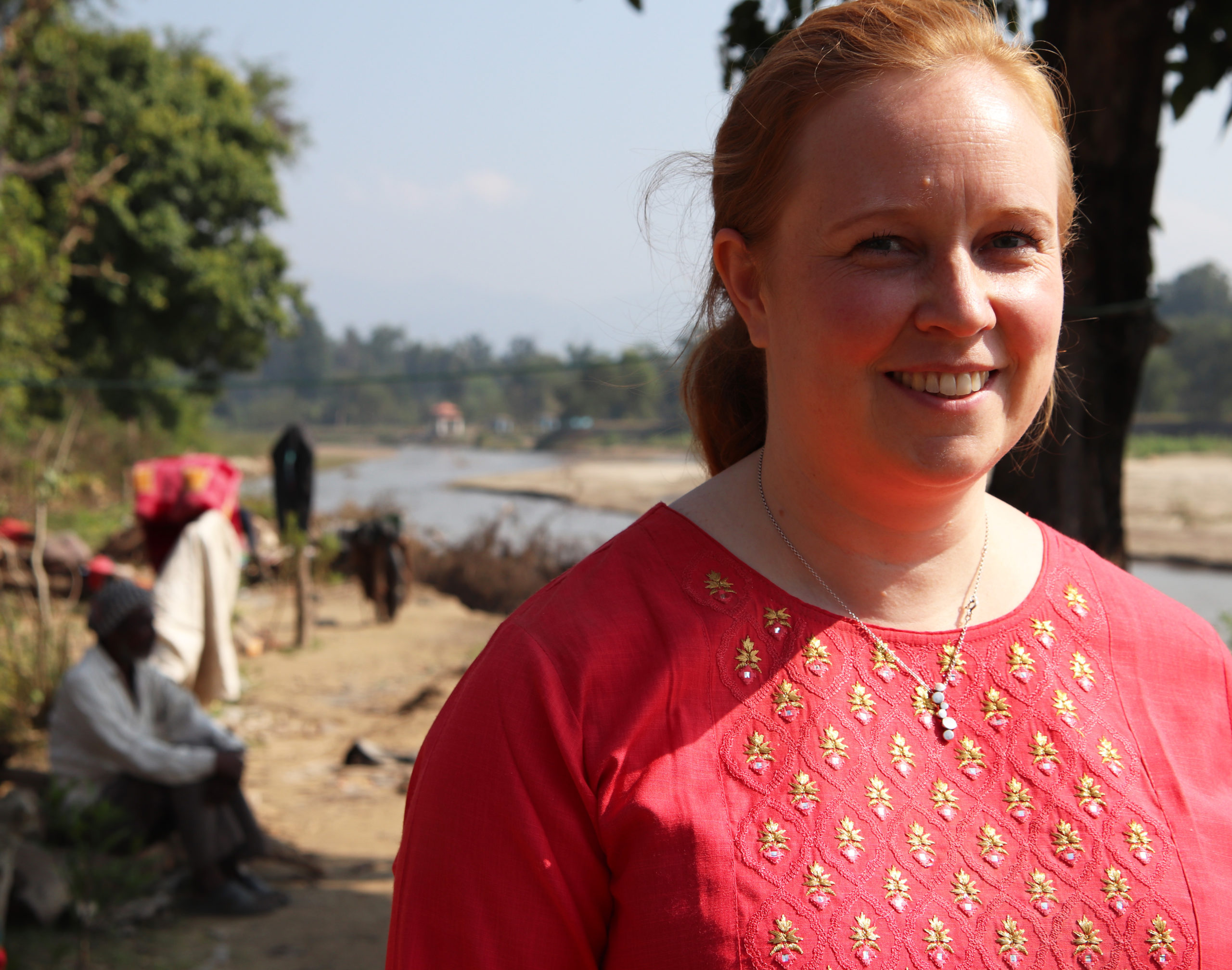 Hankehallinnon asiantuntija Terhi Teiskonlahti lähikuvassa, punainen nepalilainen asu päällään.