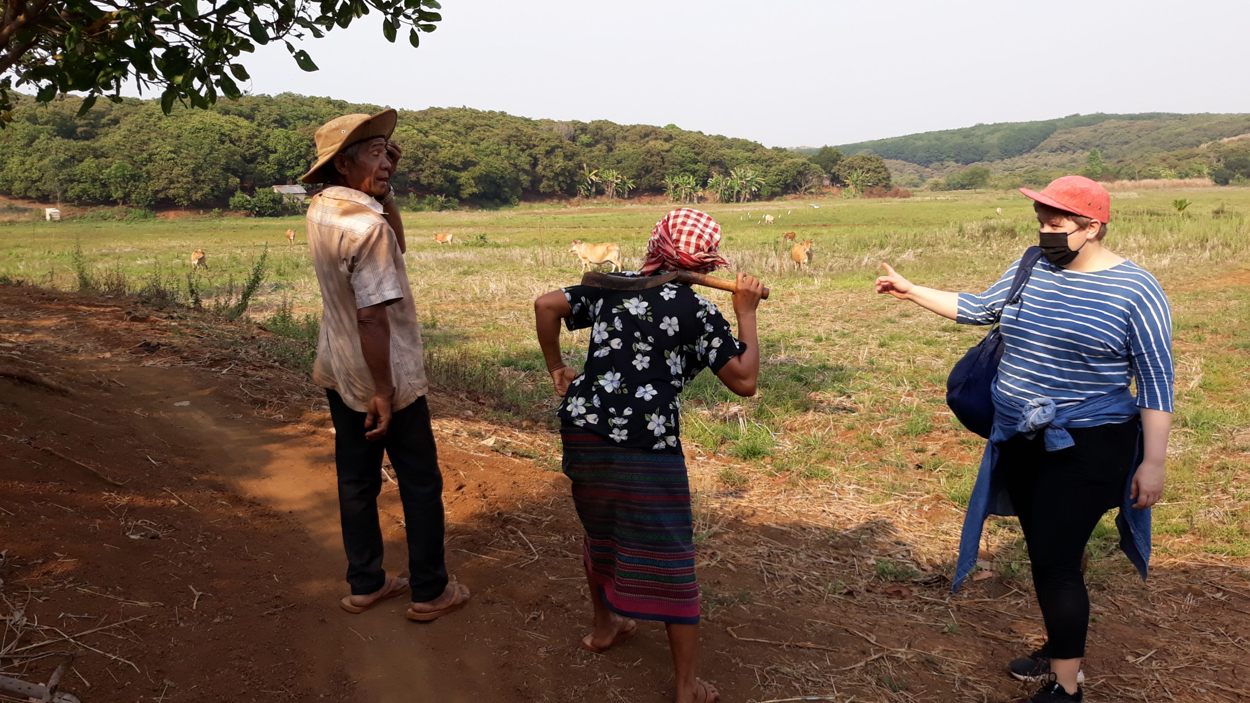Vapaaehtoinen Johanna Harjunpää juttelee maanviljelijöiden kanssa Kambodžassa.