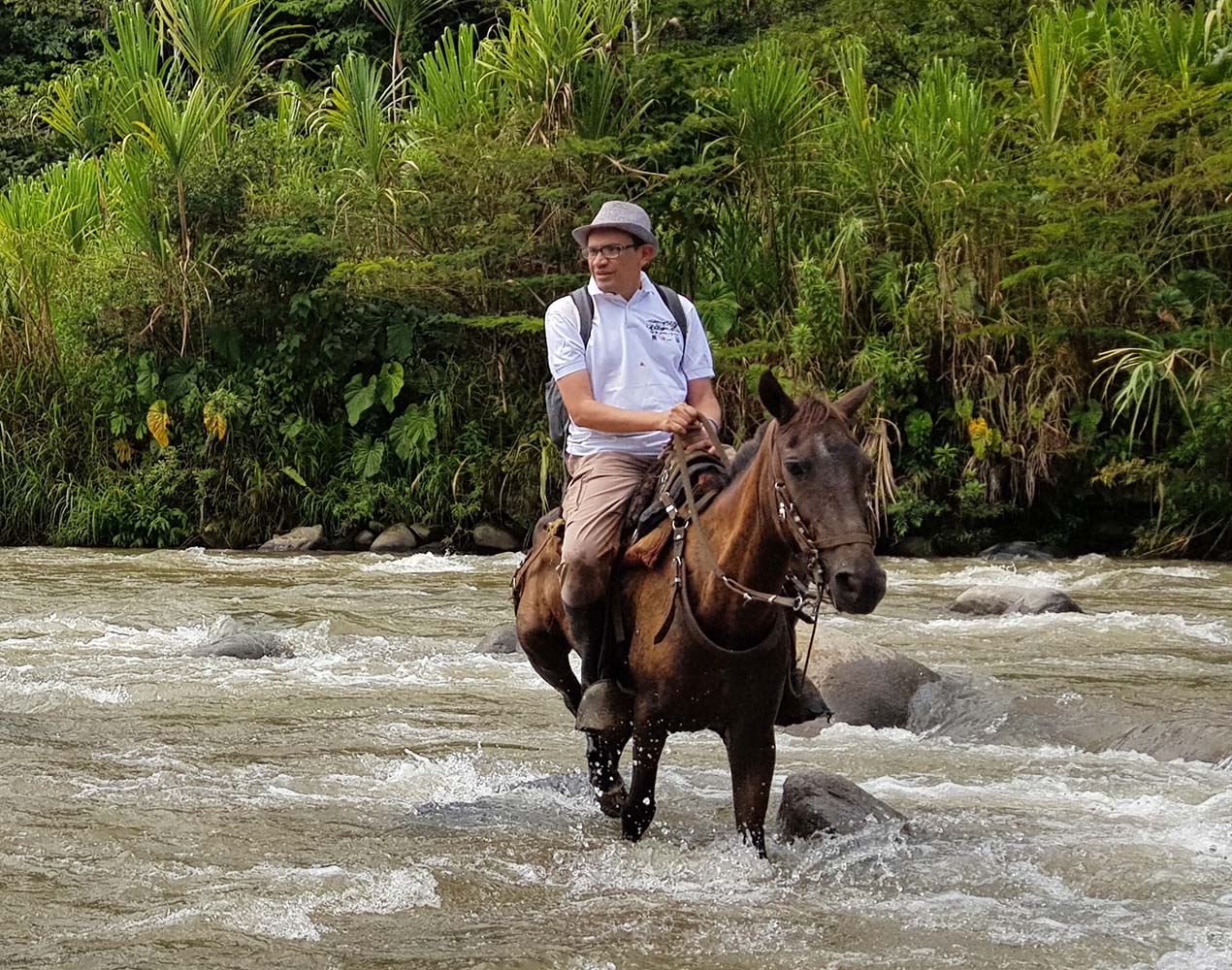 John Hernandez ratsastaa hevosella matalassa joessa.