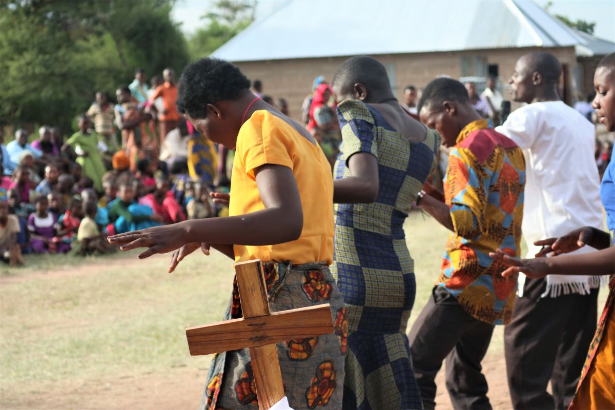 Tansanialaisia tanssimassa, puinen risti etualalla.