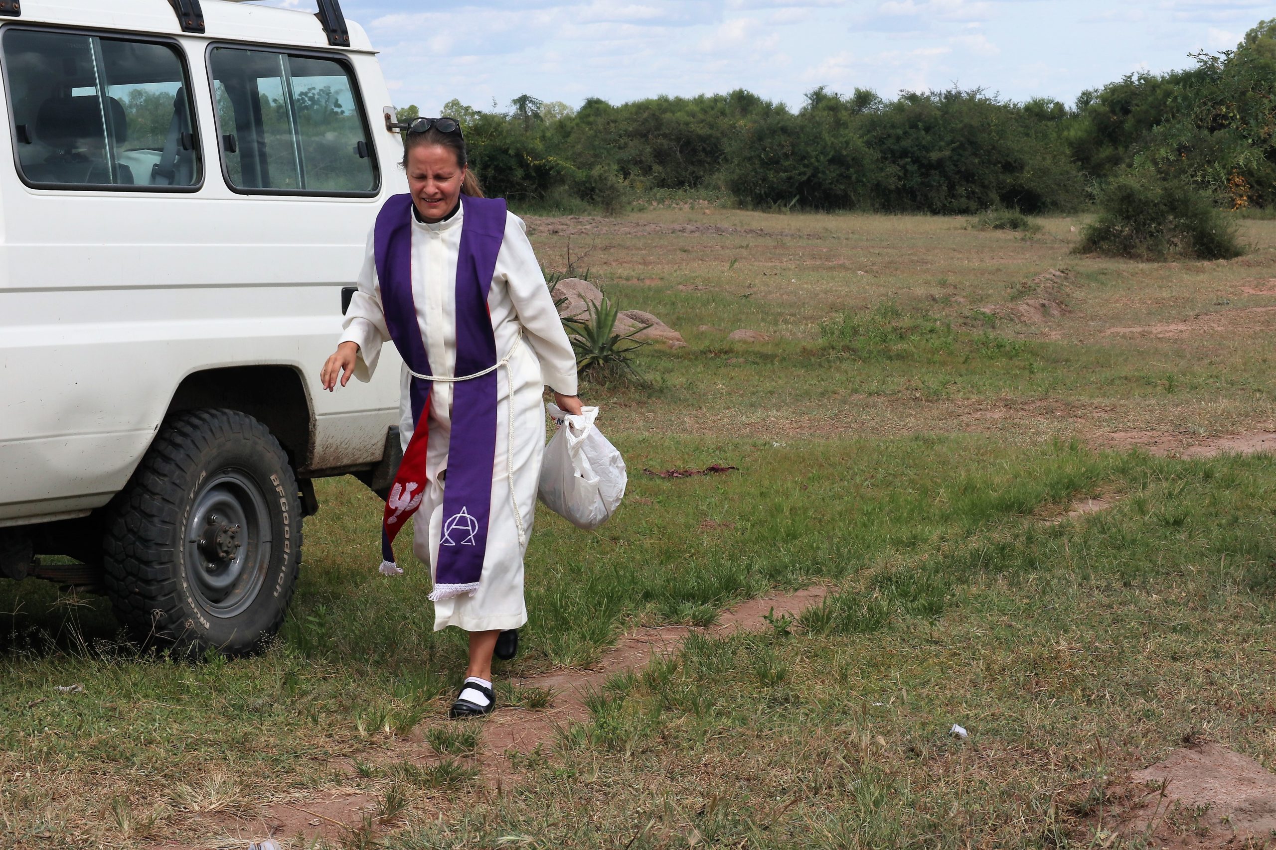 Pappi tulee autoltaan afrikkalaisessa maalaiskylässä.