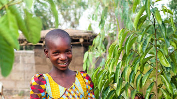 12-vuotias Happiness guavan vieressä kotipihassaan.