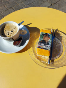 Pöydällä kahvikuppi ja leivos, jonka päällä hollantilaisen formulakuskin kuva
