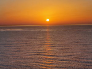Oranssinen auringonnousu aavan meren yllä