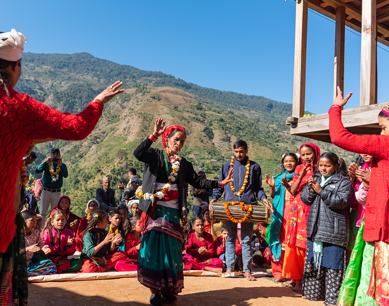 Nepalilainen nainen tanssii yhteisön edessä vuoristokylässä.