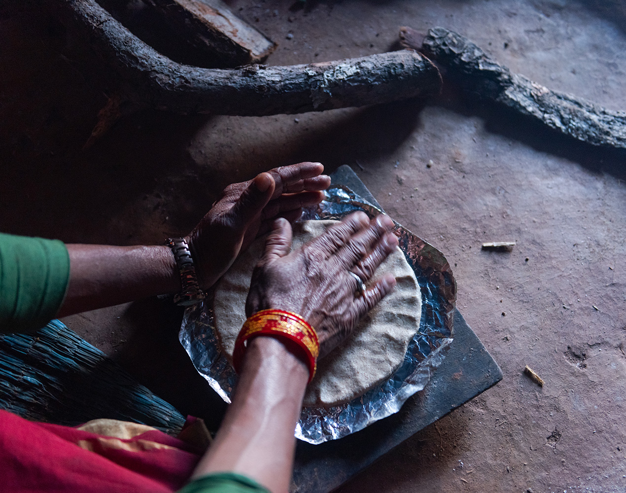 Kädet taputtelevat nepalilaista leipää vuokaan