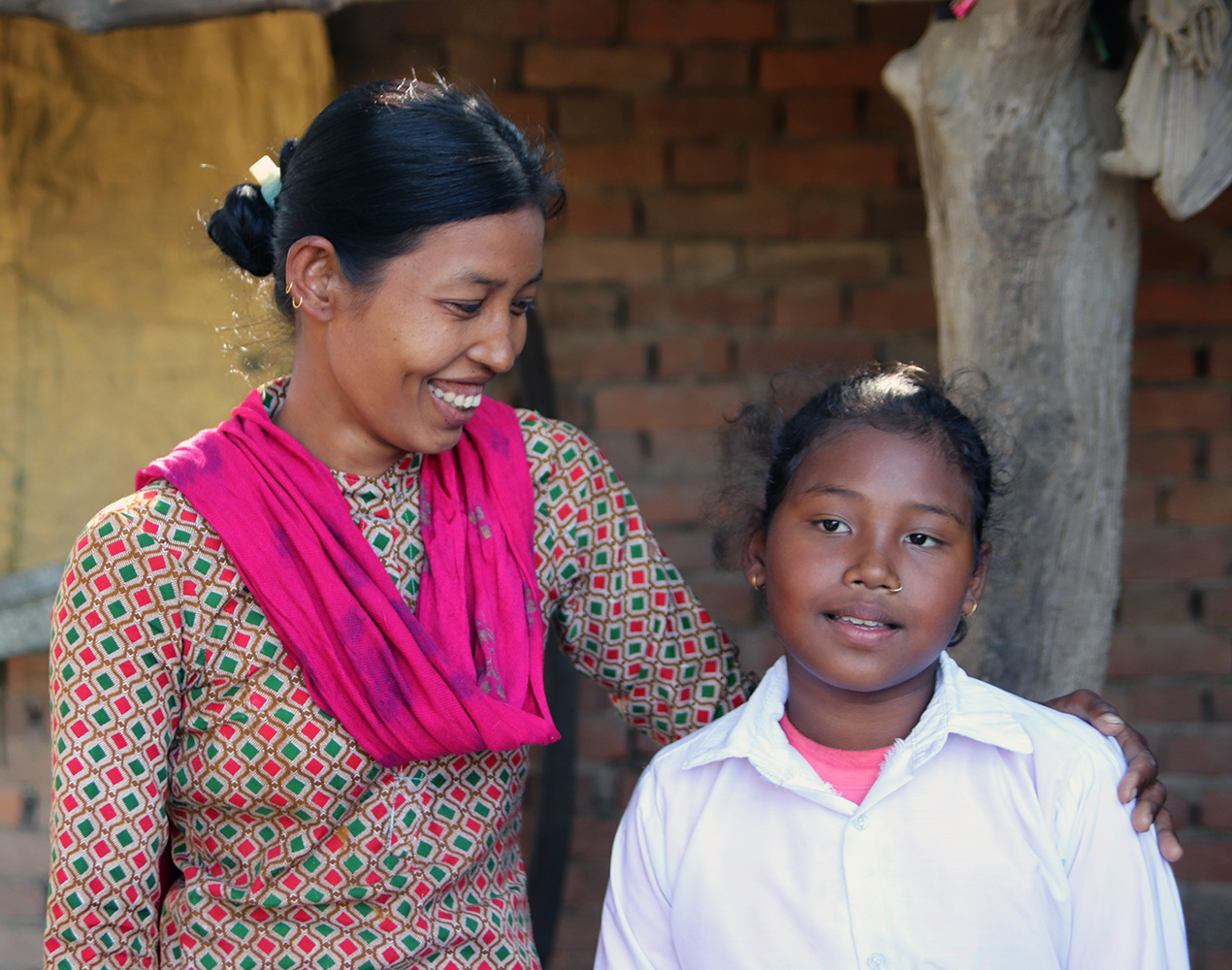 Nepalilainen äiti Shova ja tytär Kushi hymyilevät vierekkäin.