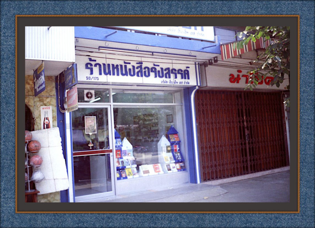 Katukuvassa kivijalkamyymälän näyteikkuna. Yläpuolella tekstiä thai-aakkosilla.
