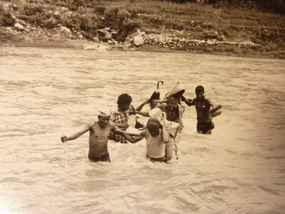 Pieni ihmisjoukko ylittää jokea Nepalissa.