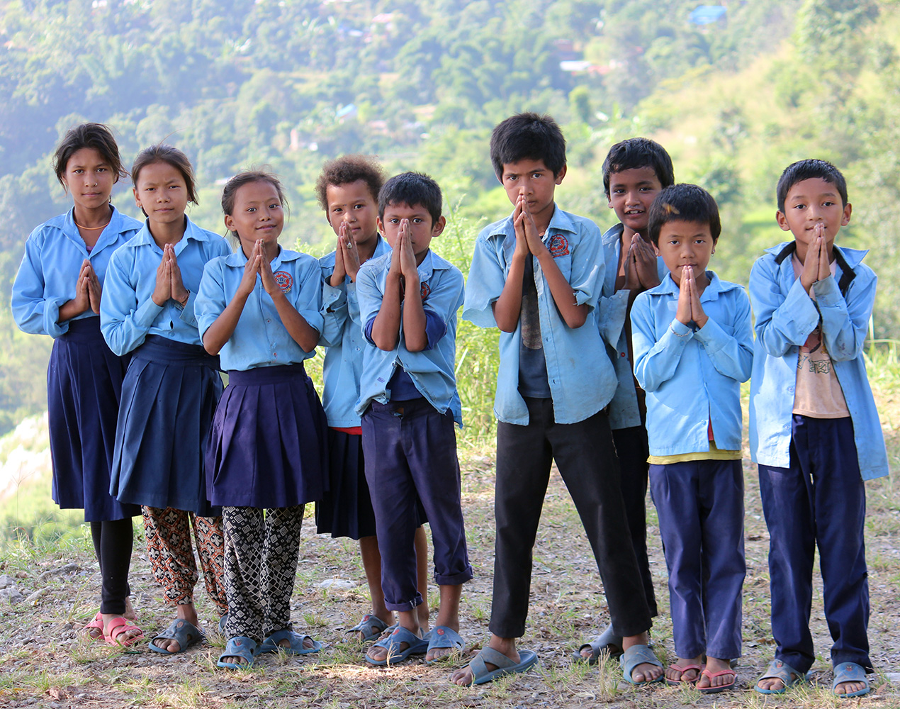 Nepalilaisia koululaisia tekemässä tervehdyselettä.