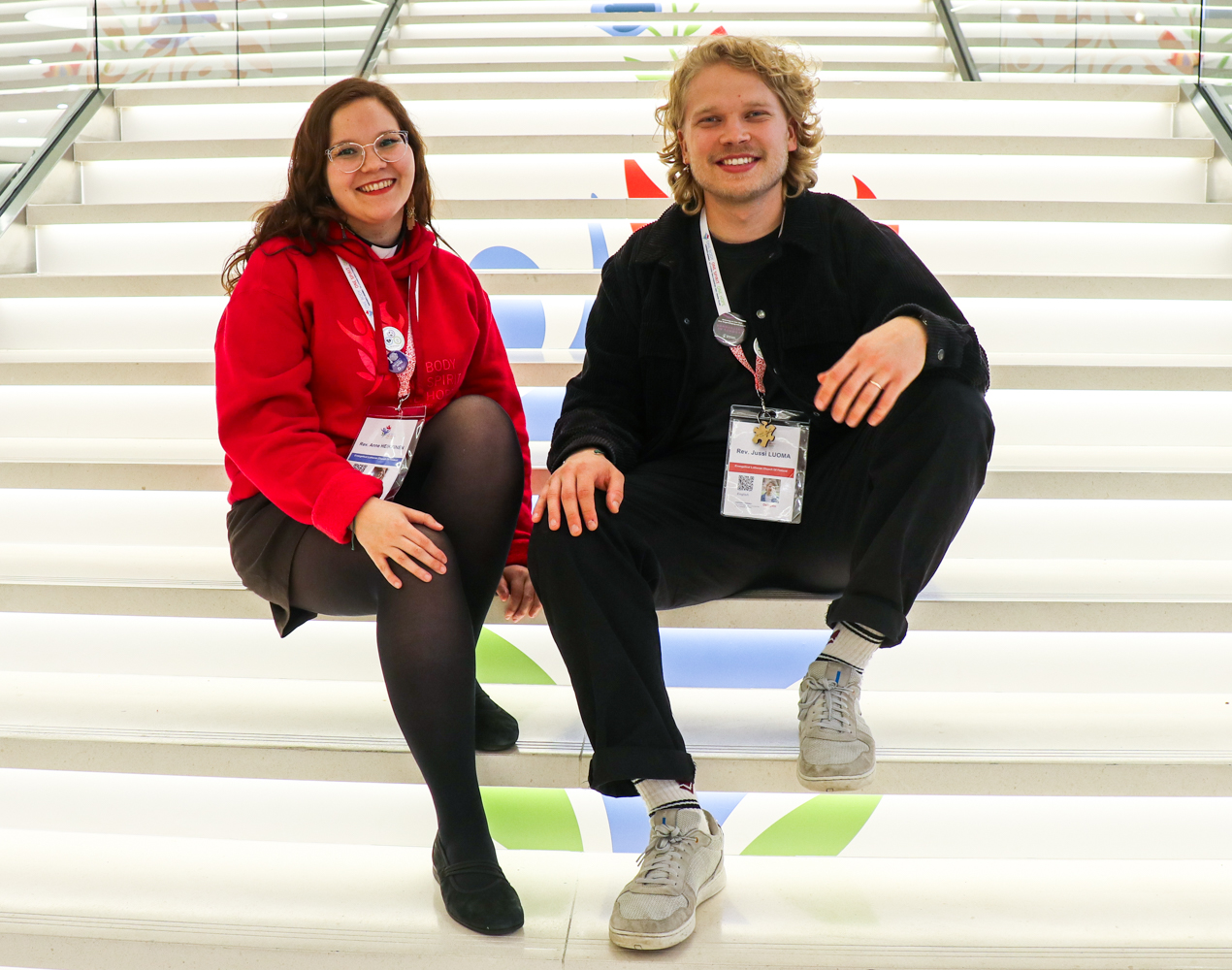 Anne Heikkinen ja Jussi Luoma istumassa konferenssikeskuksen portailla.