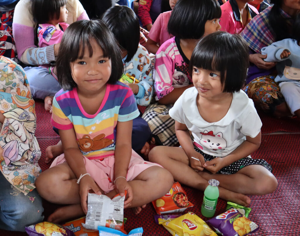Kaksi thaimaalaista lasta esittelevät saamiaan jouluherkkujaan.