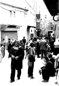 Mustavalkoisessa kuvassa ihmisiä kävelee kadulla Itä-Jerusalemissa.