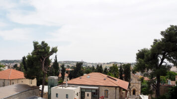 Kuvassa näkyy ylhäältä pihan puolelta kuvattuna Felm-keskuksen alatalo. Etualalla näkyy asfalttipihaa ja parkkipaikkaa, taustalla Jerusalemin vanhaa kaupunkia.